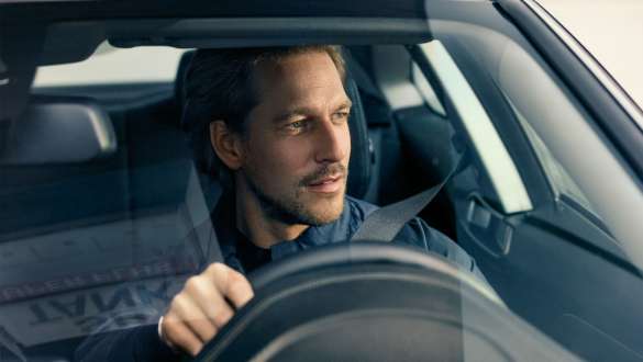 Mężczyzna za kierownicą BMW serii 5 Touring G31 Mężczyzna za kierownicą BMW z widokiem przez przednią szybę w BMW serii 5 Touring G31, modernizacja 2020