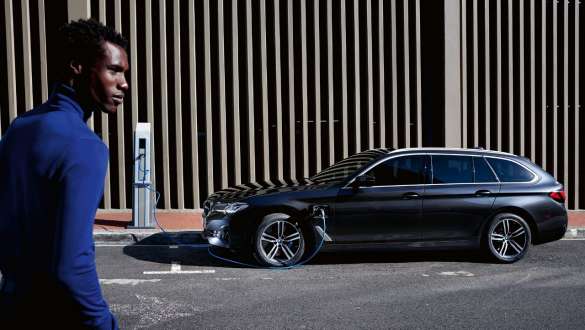 Hybryda plug-in BMW serii 5 Touring 2021 G31, widok z boku podczas ładowania Hybryda plug-in BMW serii 5 Touring 2021 G31, widok z boku podczas ładowania z modelem
