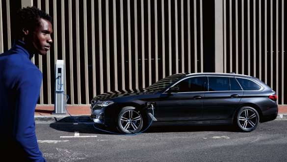 Hybryda plug-in BMW serii 5 Touring 2021 G31 LCI widok z boku podczas ładowania Hybryda plug-in BMW serii 5 Touring 2021 G31 LCI widok z boku podczas ładowania z modelem