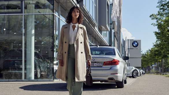Kobieta przed salonem BMW BMW Service Inclusive, kobieta przed dealerem BMW