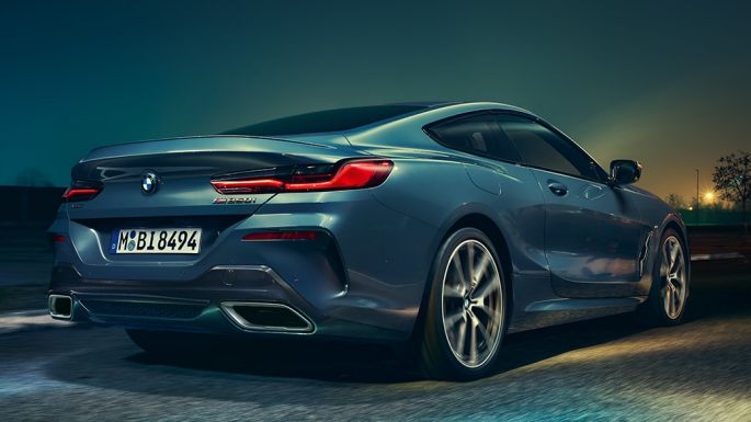 BMW M850i xDrive Coupé, widok z tyłu. BMW M850i xDrive Coupé w metalizowanym kolorze niebieskim Barcelona, widok z tyłu, jadące w nocy.