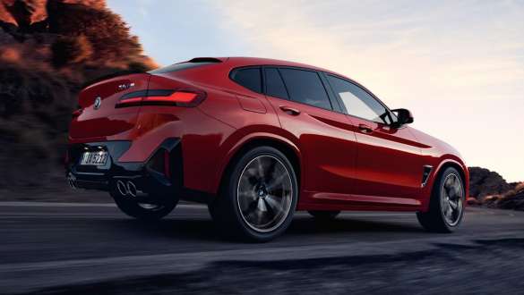 M xDrive BMW X4 M F98 LCI modernizacja 2021 BMW X4 M F98 LCI modernizacja 2021 M xDrive tylny półprofil podczas jazdy na ulicy