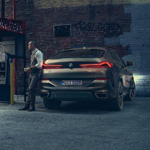 Tył BMW X6. BMW X6 w perspektywie od tyłu na tle scenerii miejskiej.