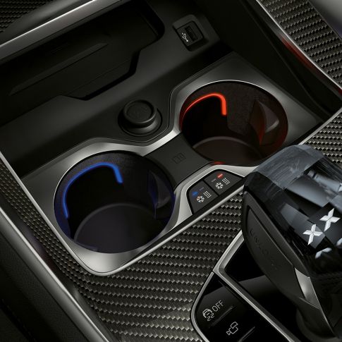 Uchwyt na napój z regulacją temperatury. Zbliżenie wnętrza BMW z widokiem uchwytu na napój z regulacją temperatury.
