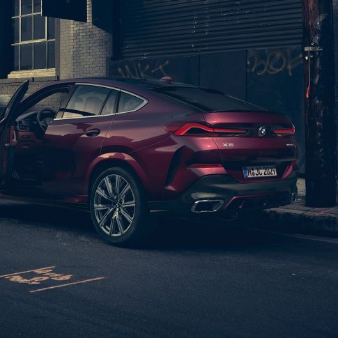 Widok BMW X6 Individual od tyłu. BMW X6 Individual stojący w miejscu w ujęciu z półprofilu od tyłu.