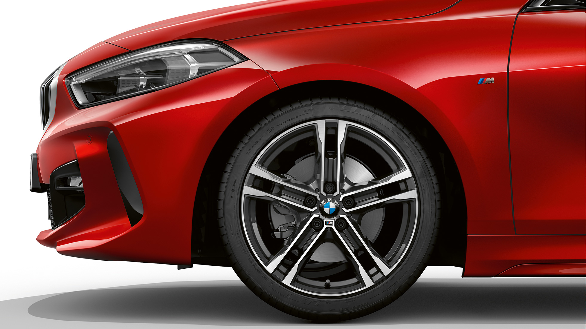 BMW serii 1, model M Sport, w metalizowanym kolorze czerwień Melbourne, przód z boku, z 17-calową obręczą ze stopów lekkich Double Spoke 550 M Bicolor.