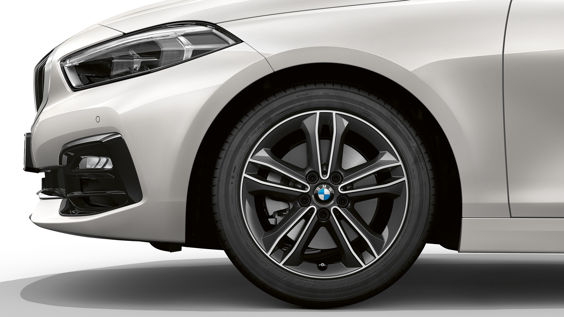 17-calowa obręcz kół ze stopów lekkich Double Spoke 549. BMW serii 1, model Sport Line, w metalizowanym kolorze bieli mineralnej, przód z boku z 17-calową obręczą ze stopów lekkich Double Spoke 549.