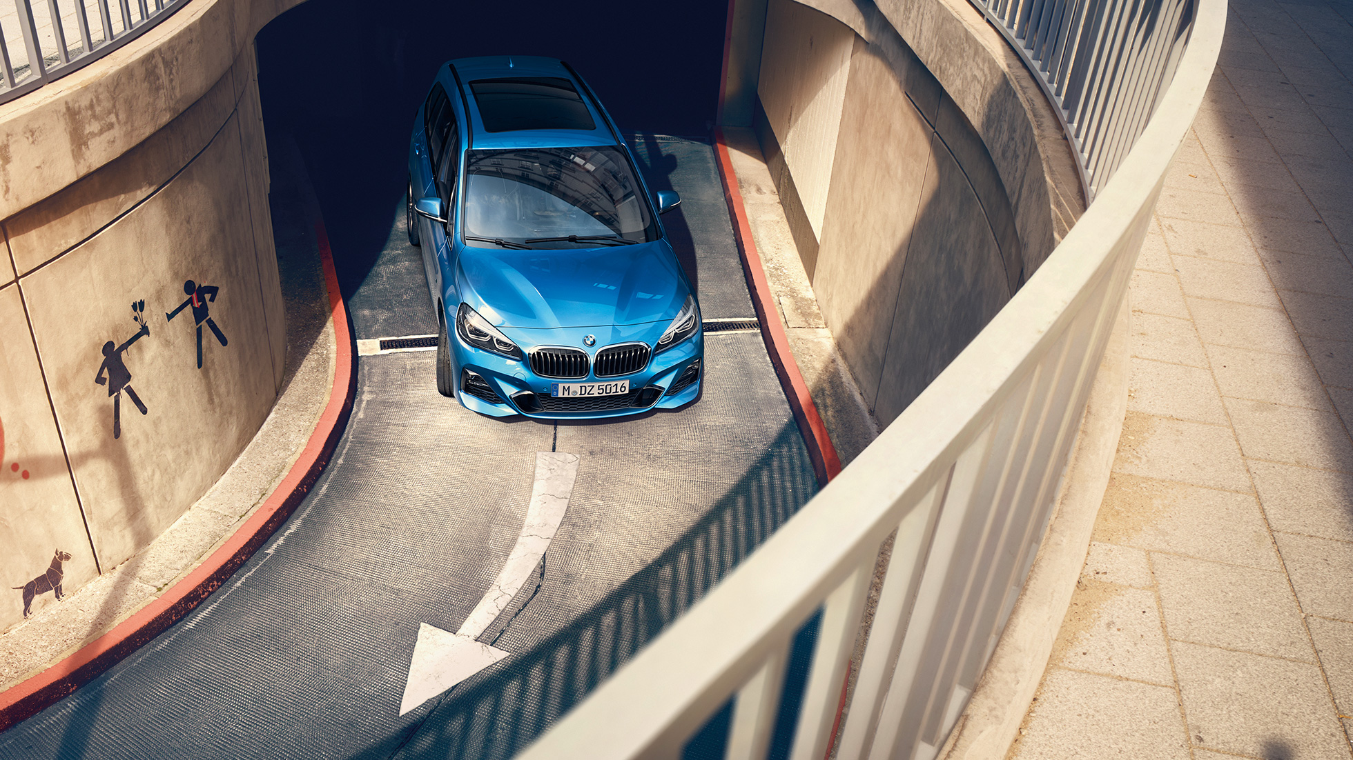 BMW serii 2 Gran Tourer podczas jazdy na parkingu wielopoziomowym BMW serii 2 Gran Tourer F46, modernizacja 2018, niebieski Estoril, metalizowany, widok z góry podczas jazdy na parkingu wielopoziomowym