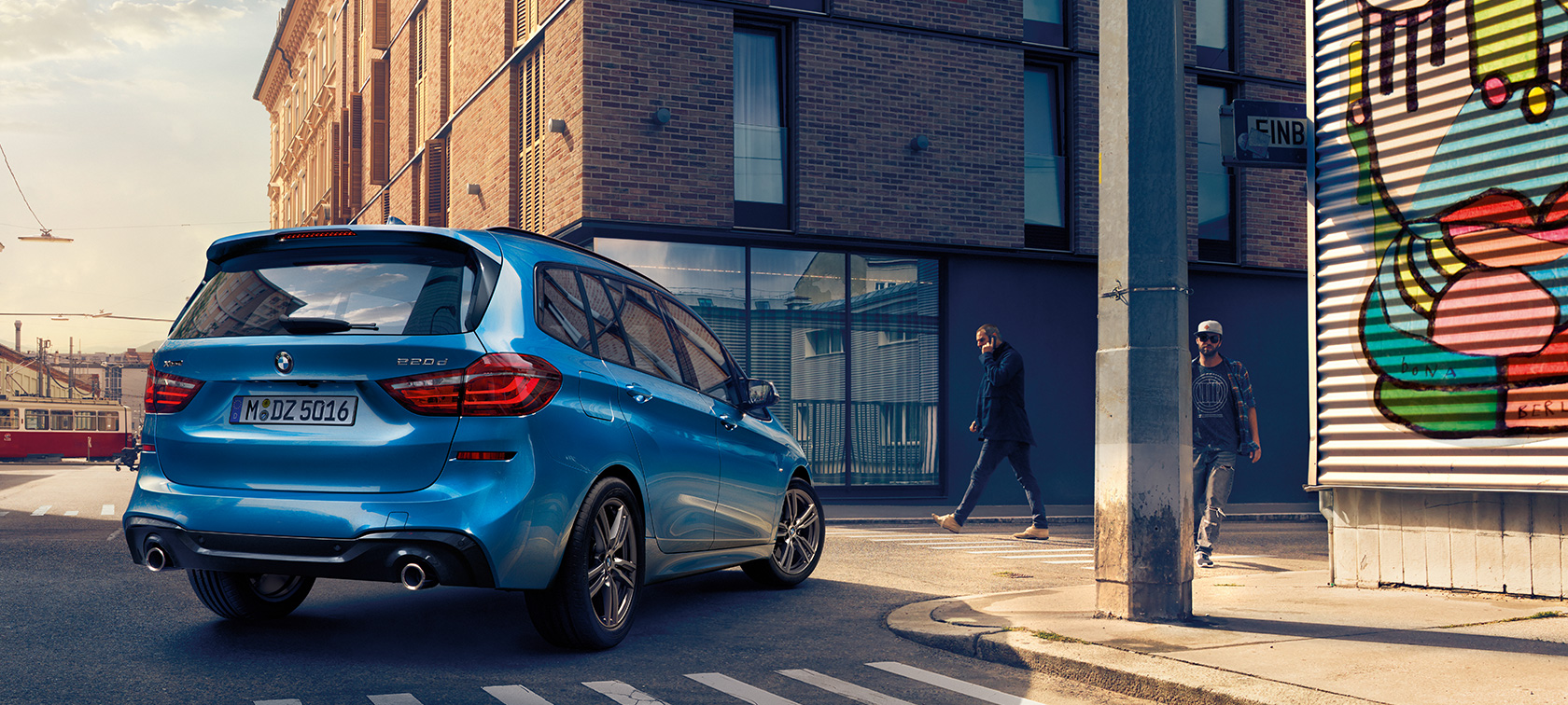 BMW serii 2 Gran Tourer w widoku z góry Mężczyzna obok BMW serii 2 Gran Tourer F46, modernizacja 2018, niebieski Estoril, metalizowany, widok z góry na samochód parkujący na drodze
