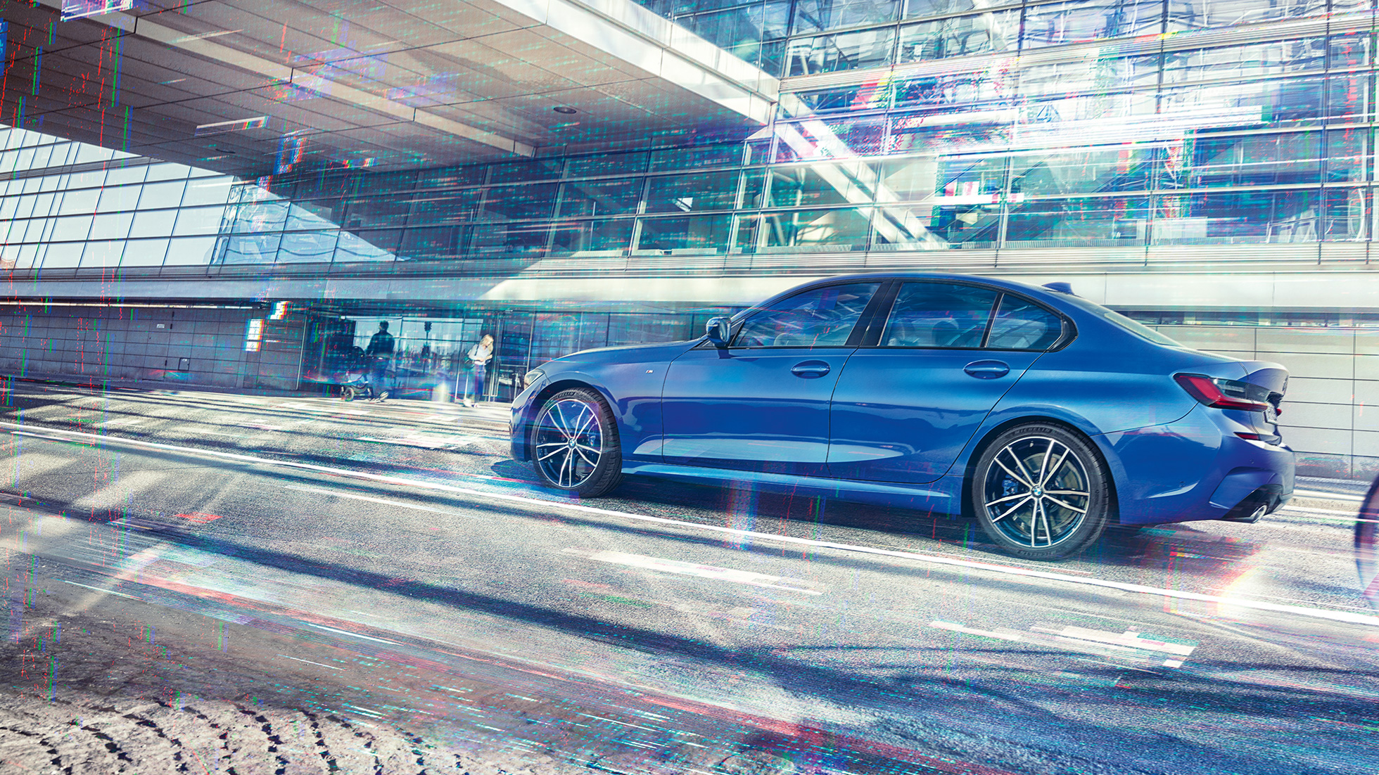 BMW serii 3, widok z boku. Stateczne ujęcie BMW serii 3 z boku w ciągu dnia przed szklanym budynkiem.