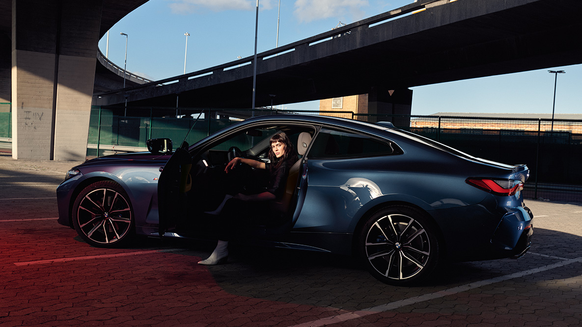 Widok z boku obręczy kół ze stopów lekkich BMW serii 4 Coupé G22 2020 BMW serii 4 Coupé G22 2020, niebieski Arctic Race, metalizowany, widok z boku, obręcze kół ze stopów lekkich, model siedzący w samochodzie z otwartymi drzwiami