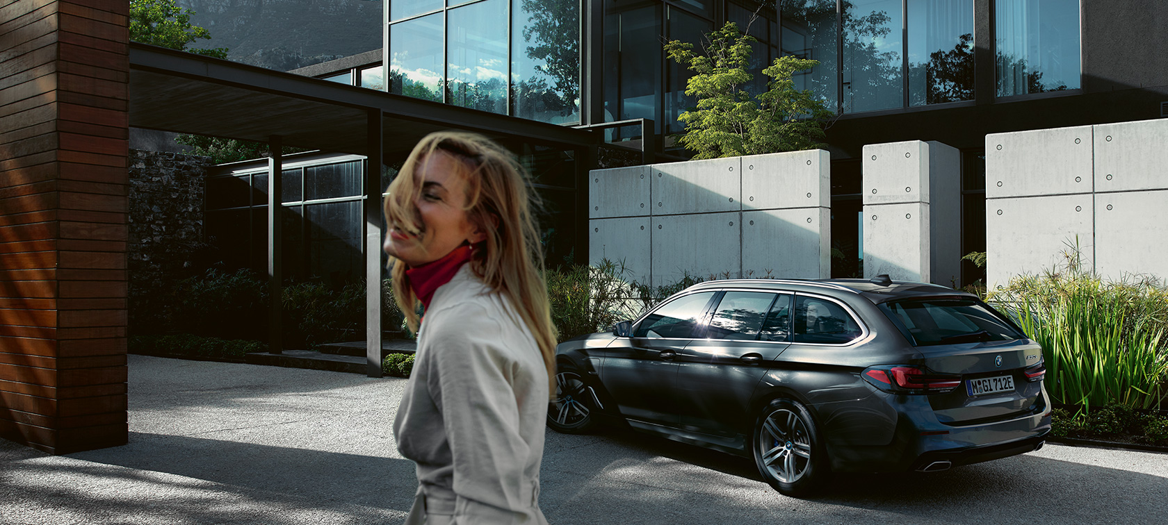 Kobieta przed zaparkowanym BMW serii 5 Touring G31 BMW serii 5 Touring G31, modernizacja 2020, kobieta stojąca przed zaparkowanym BMW