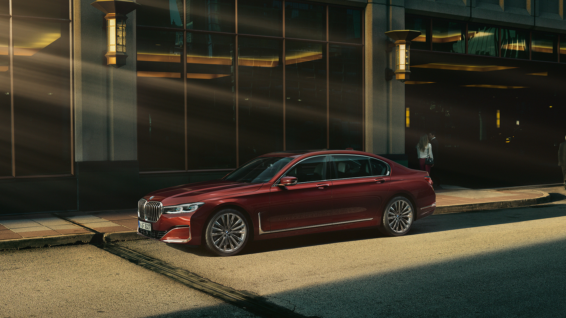 BMW Individual serii 7 Limuzyna, profil Czerwone BMW Individual serii 7 Limuzyna z profilu na tle miasta