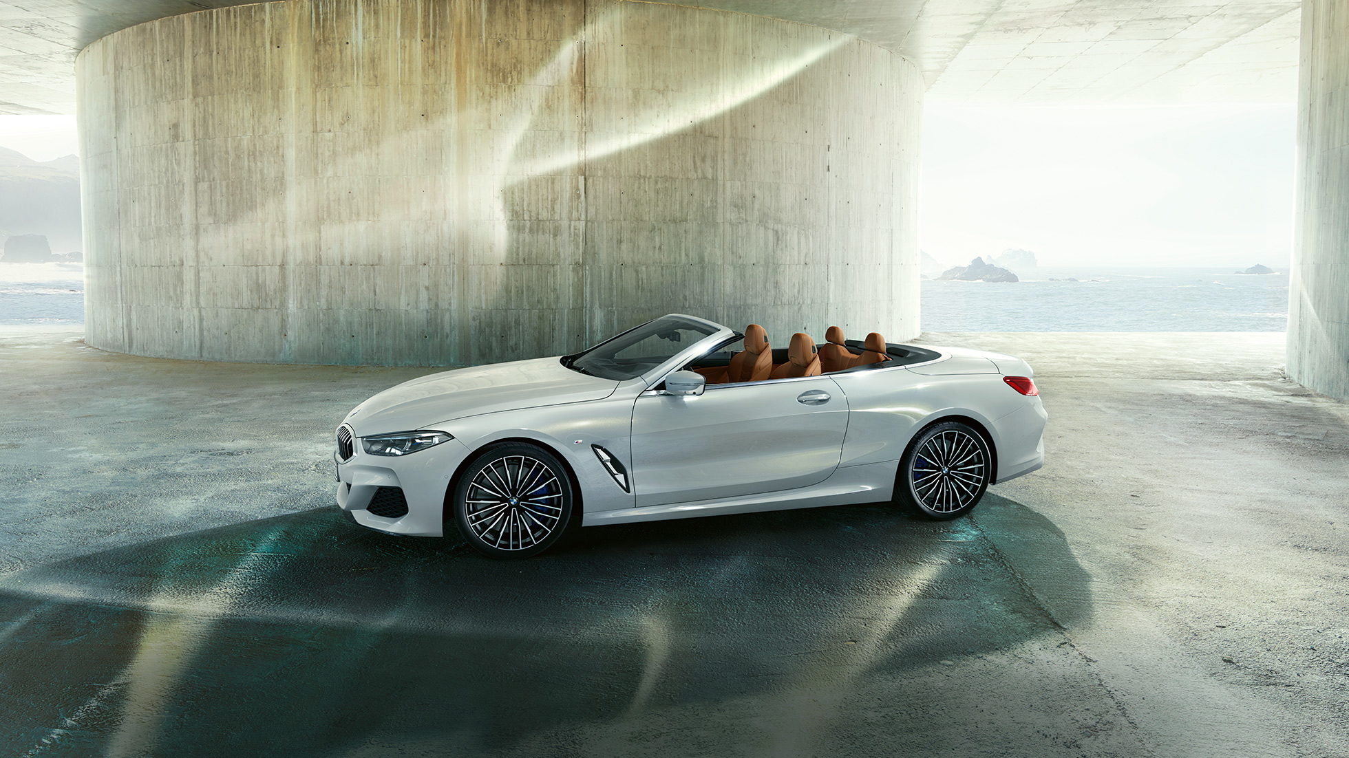 BMW M850i xDrive, biel mineralna metalizowana, widok z boku z otwartym dachem. BMW M850i xDrive, biel mineralna metalizowana, widok z boku z otwartym dachem.