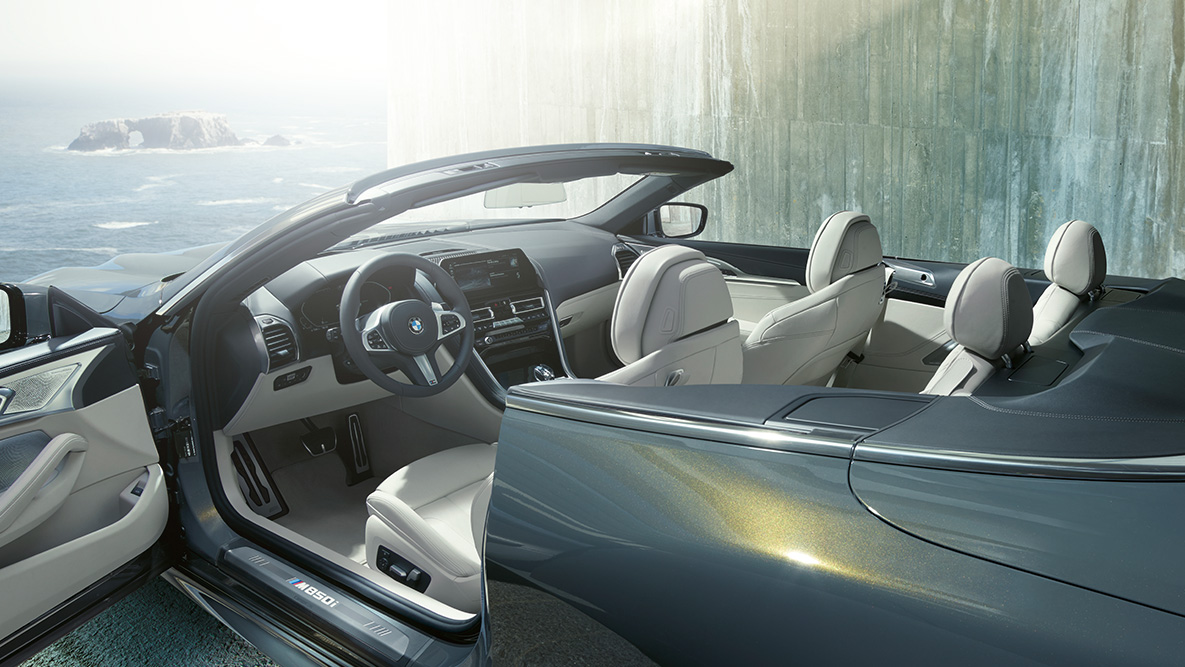 BMW M850i xDrive, szary drawit metalizowany, wnętrze, miękki dach i otwarte drzwi. BMW M850i xDrive, szary drawit metalizowany, wnętrze, miękki dach i otwarte drzwi.