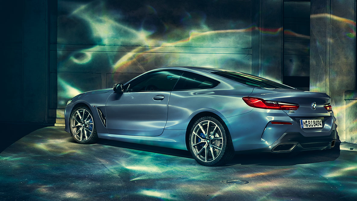 BMW serii 8 Coupé, tylny półprofil. Tylny półprofil BMW serii 8 Coupé w nocnej, miejskiej scenerii.