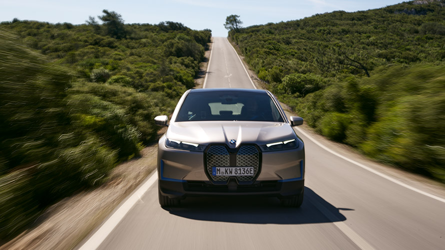 BMW iX, widok z przodu na drodze BMW iX, srebrny Kaszmir, i20, widok z przodu na drodze