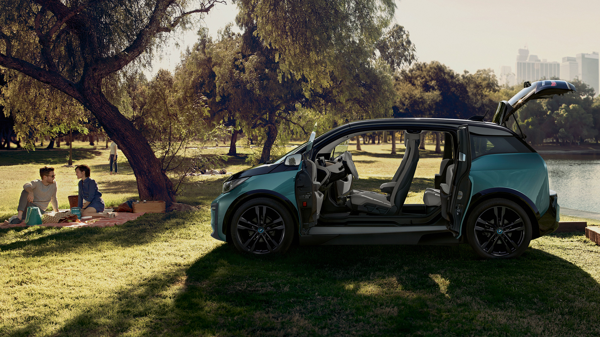 BMW i3 2018, widok z boku z otwartymi drzwiami BMW i3 I01 2018, beż Jucaro z akcentami w metalizowanym kolorze mroźnym szarym, widok z boku z otwartymi drzwiami