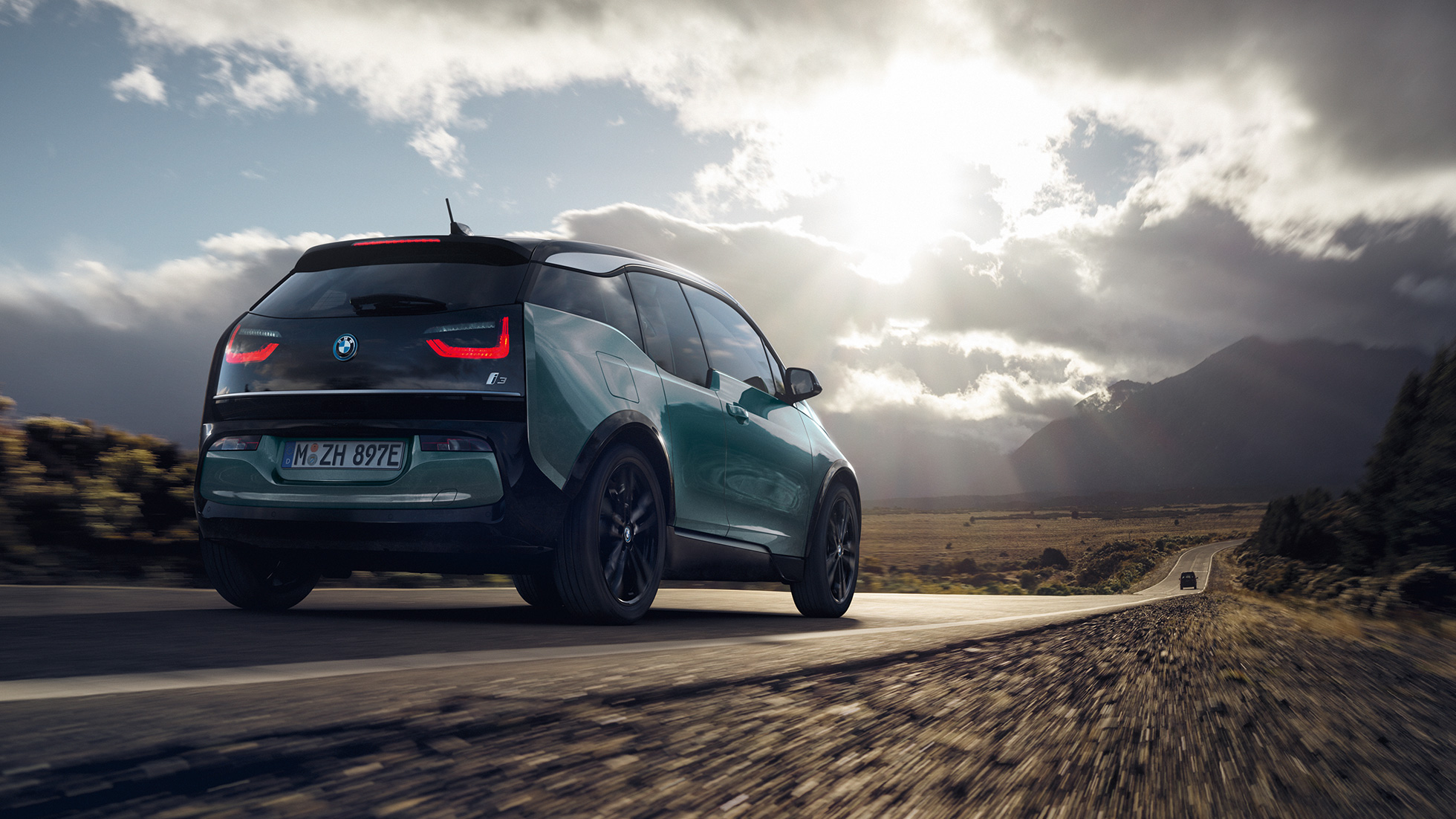 BMW i3 2018, tylny półprofil podczas jazdy poza miastem BMW i3 I01 2018, beż Jucaro z akcentami w metalizowanym kolorze mroźnym szarym, tylny półprofil podczas jazdy poza miastem