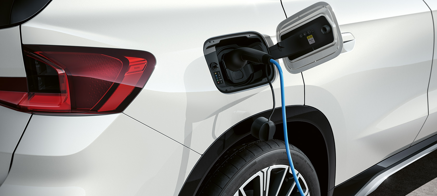 BMW iX1 U11 BEV 2022 klapka gniazda ładowania BMW iX1 U11 BEV 2022 biel mineralna metalizowany otwarta klapka gniazda ładowania podczas ładowania
