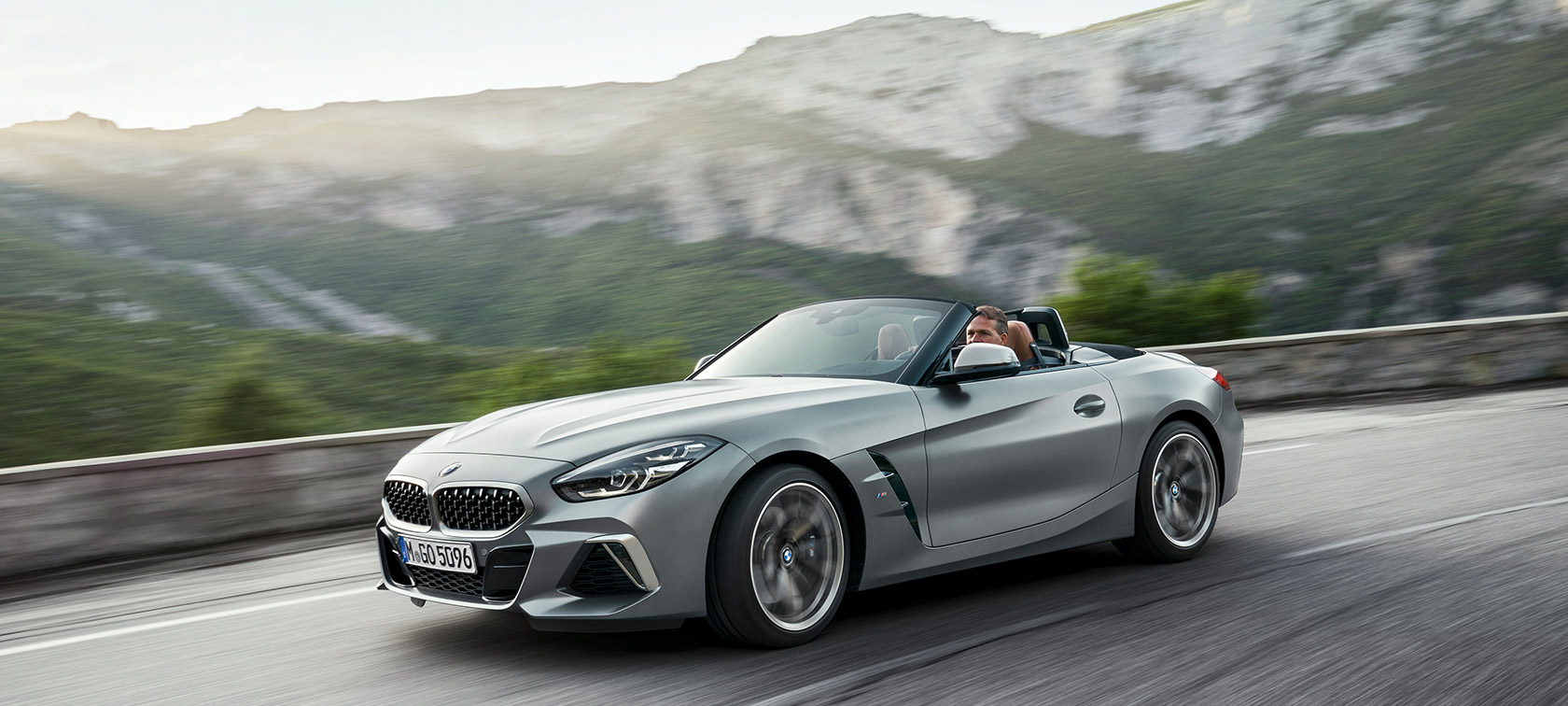 BMW Z4 M40i podczas jazdy na tle gór BMW Z4 Roadster M40i 2019 Cabrio, BMW Individual mroźny szary, metalizowany, przedni półprofil podczas jazdy na tle gór