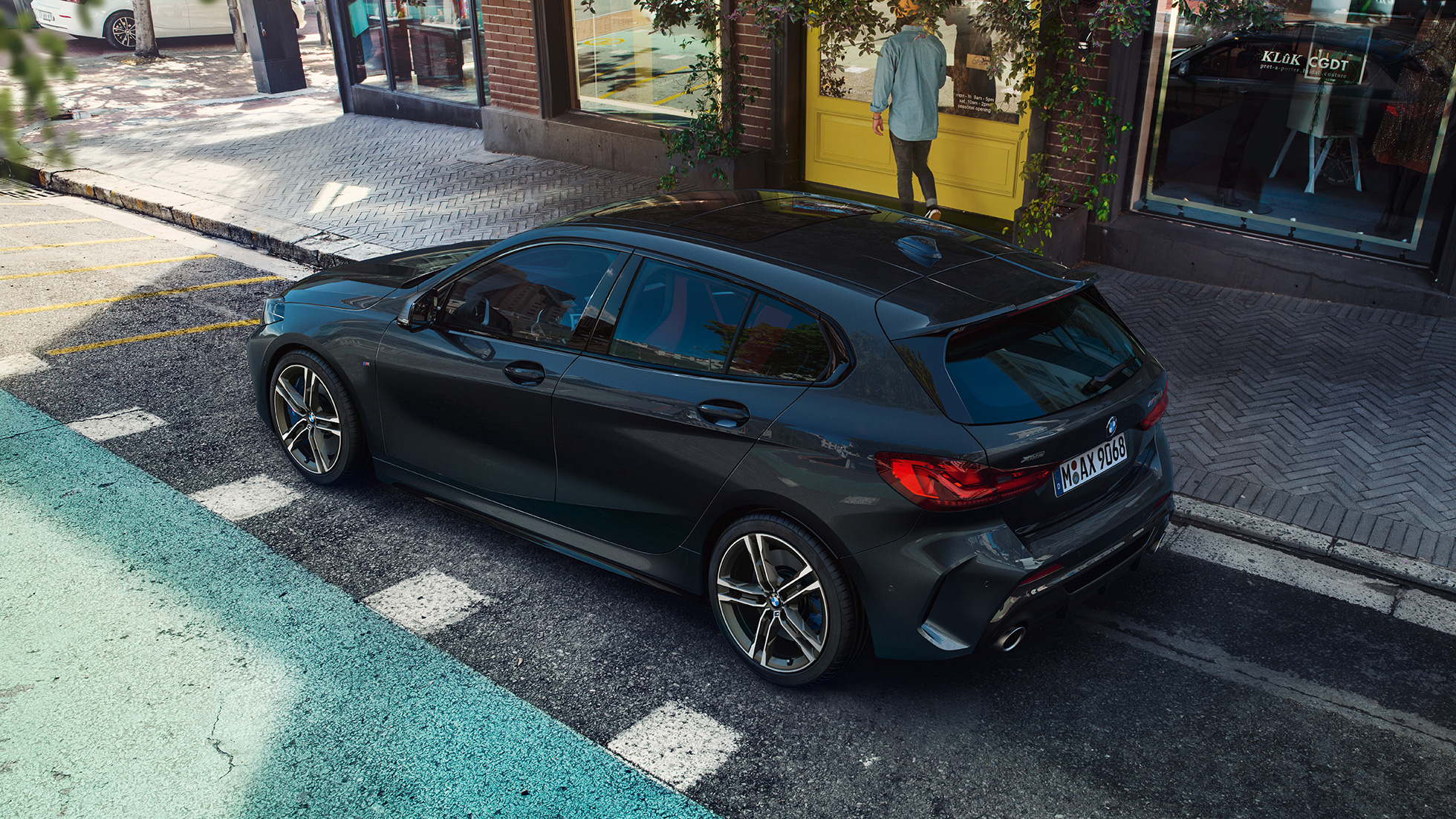 BMW M135i xDrive, zaparkowane. BMW M135i xDrive w metalizowanym kolorze szafirowoczarnym, zaparkowane, widok z boku z lotu ptaka.