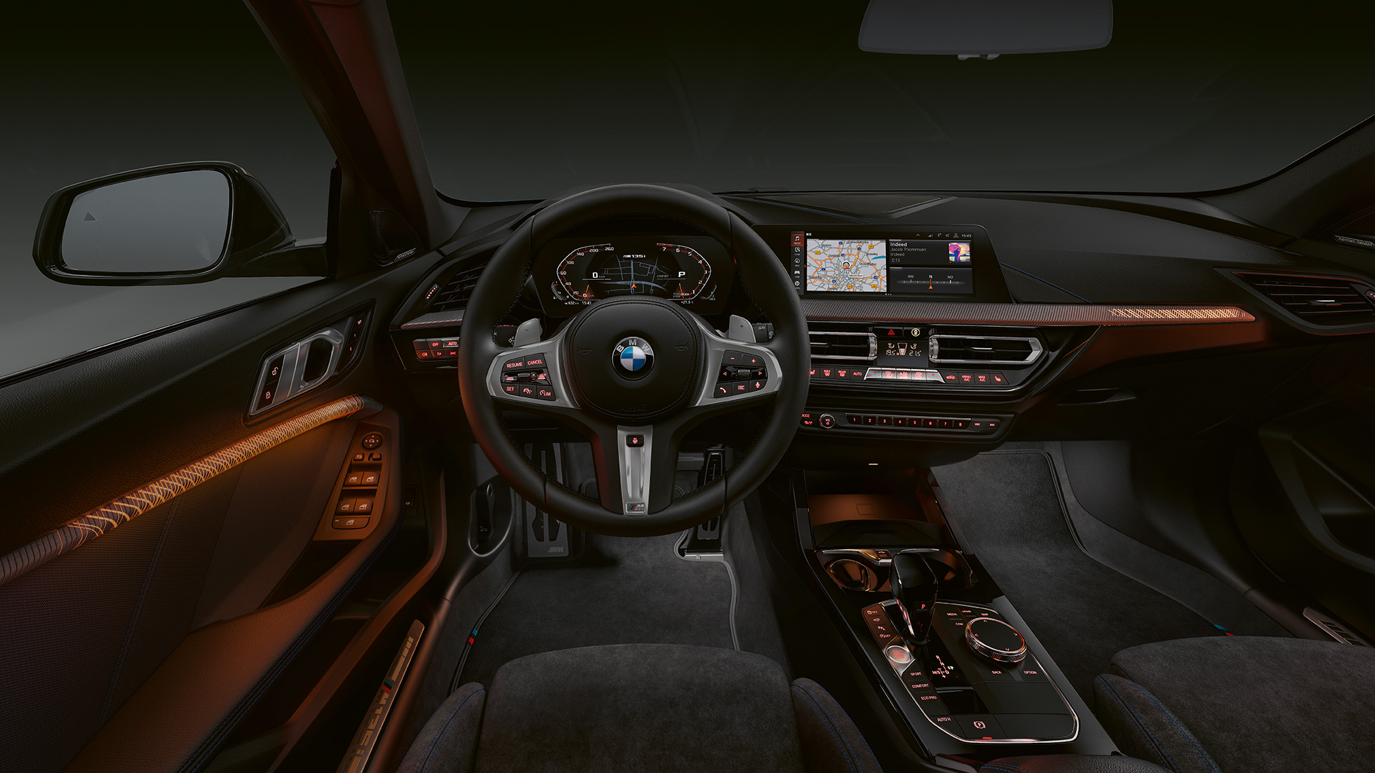 BMW M135i xDrive, kokpit. Wnętrze klasy premium BMW M135i xDrive z podświetlanymi listwami ozdobnymi.