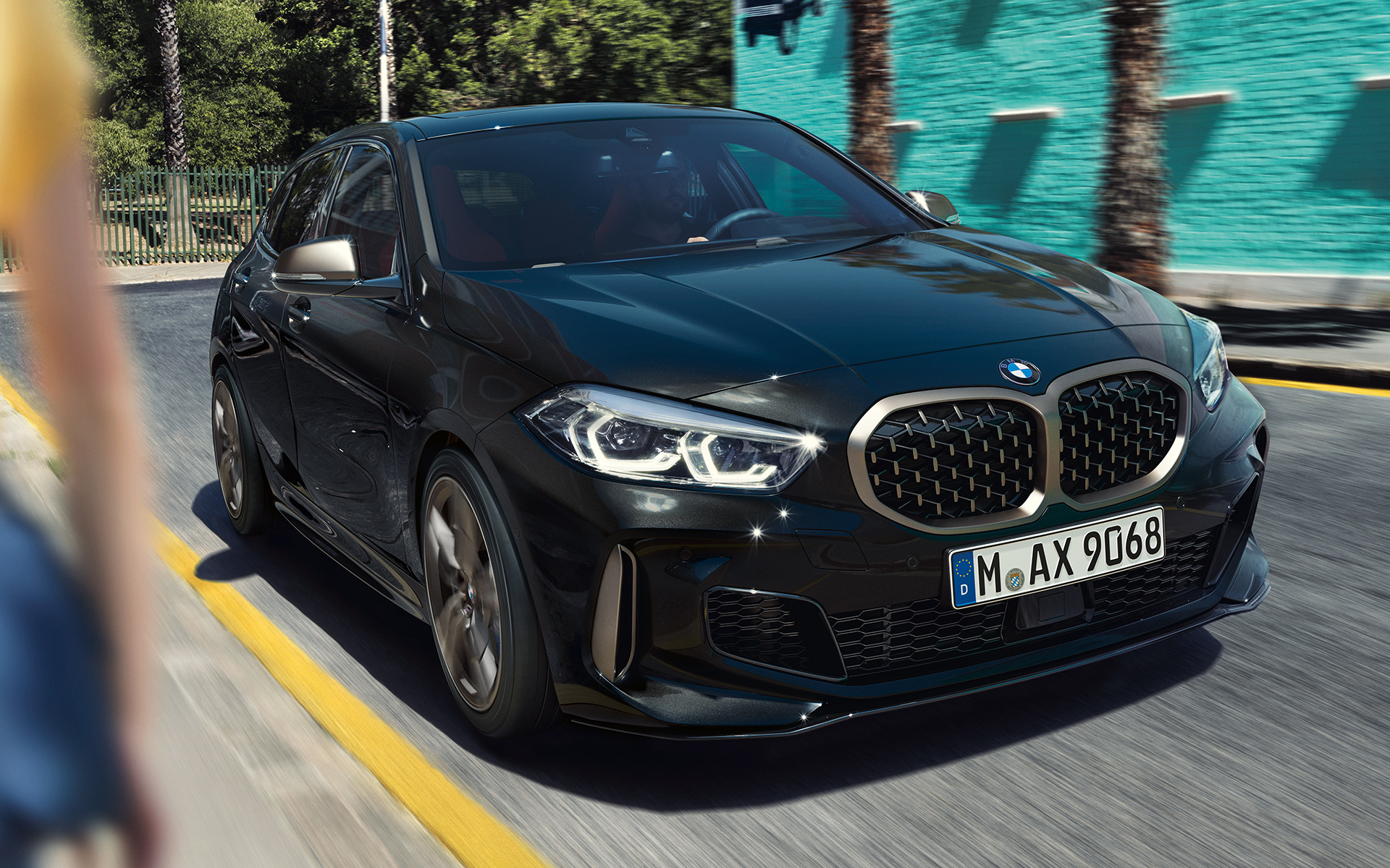 BMW M135i xDrive (F40) w metalizowanym kolorze szafirowoczarnym, przedni półprofil podczas jazdy