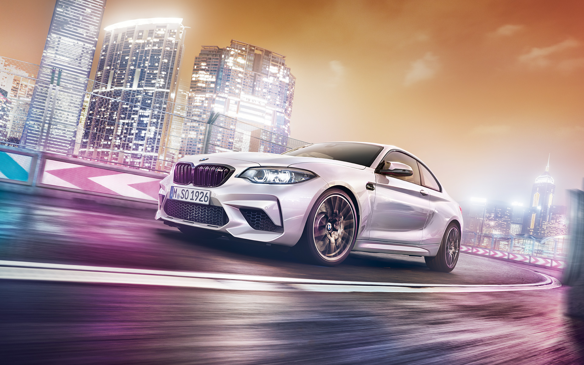 Białe BMW M2 Competition z horyzontem. Białe BMW M2 Competition podczas jazdy na torze wyścigowym z perspektywą nocnego widoku.