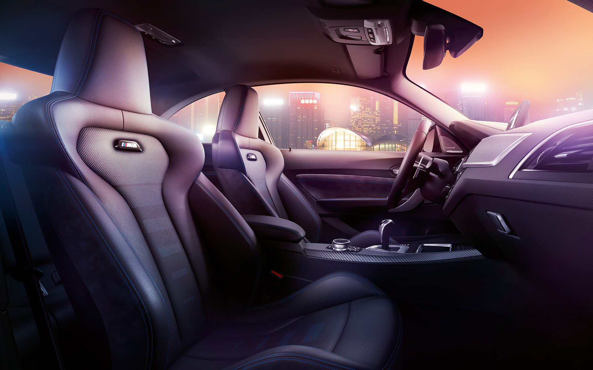 BMW M2 Competition sportowe fotele. Cockpit i sportowe fotele M w BMW M2 Competition z nocnym widokiem w tle.