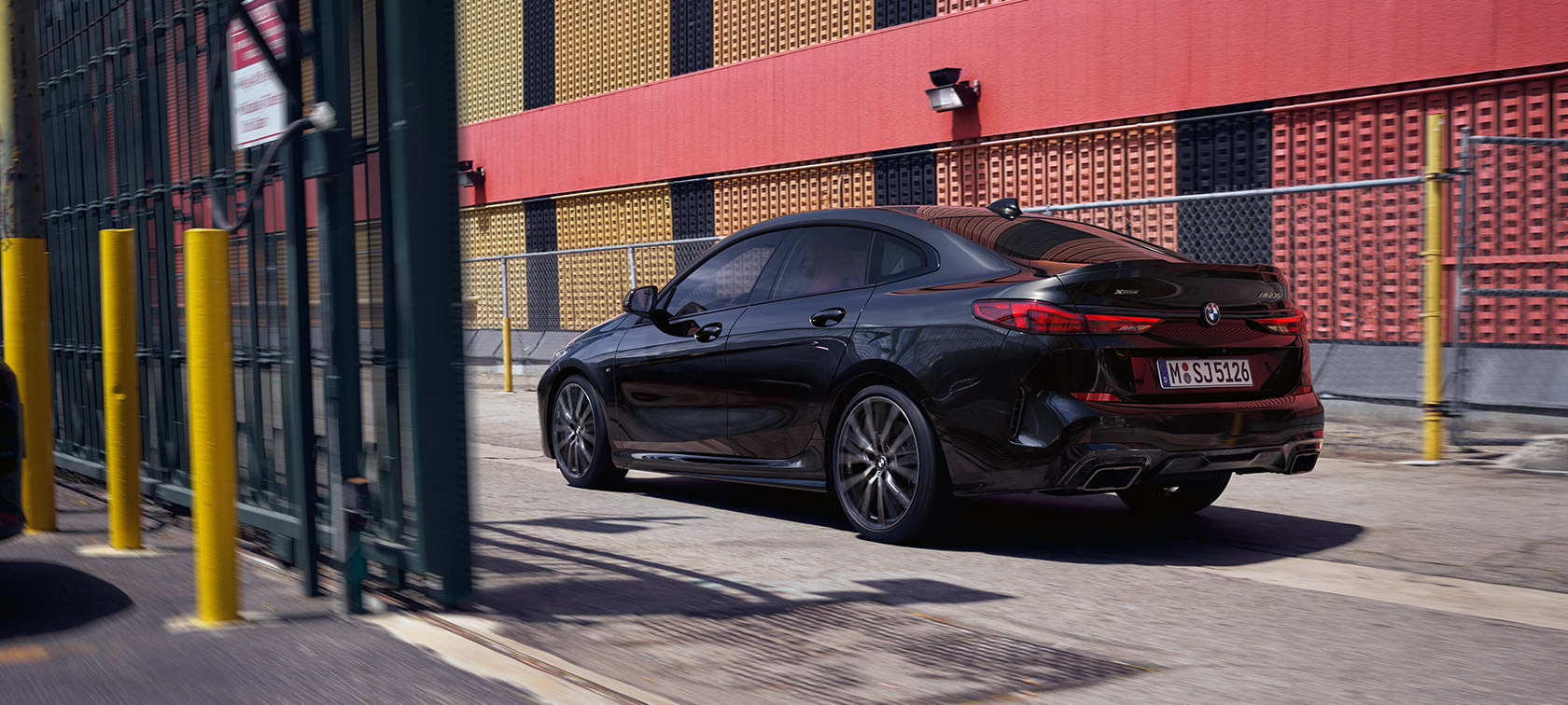 BMW M235i xDrive Gran Coupé F44 tylny półprofil podczas jazdy BMW M235i xDrive Gran Coupé F44 szafirowoczarny metalizowany tylny półprofil podczas jazdy