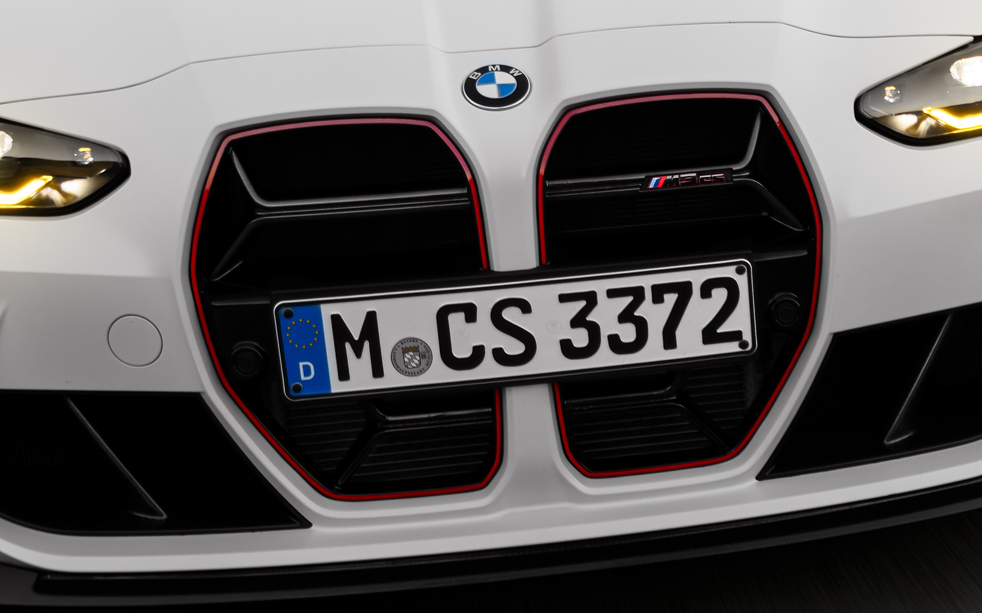 Atrapa chłodnicy w kolorze czarną sygnaturą modelu specjalnego BMW M3 CS G80 BMW M3 CS G80 atrapa chłodnicy CS w kolorze czarnym z czerwoną sygnaturą modelu specjalnego widok z przodu podczas jazdy