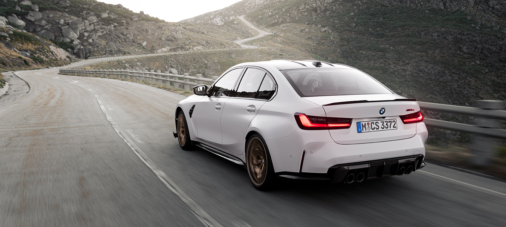 BMW M3 CS G80 tylny półprofil podczas jazdy BMW M3 CS G80 tylny półprofil podczas jazdy na drodze w górach