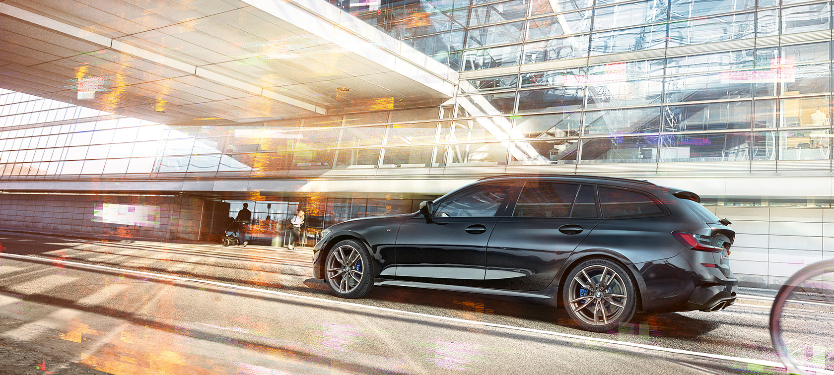 BMW M340i xDrive Touring,, boczne dynamiczne ujęcie BMW M340i xDrive Touring,, boczne dynamiczne ujęcie przed szklanym budynkiem