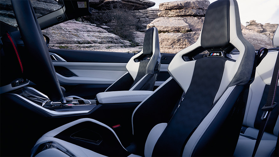 Karbonowe fotele kubełkowe M BMW M4 Cabrio Competition z M xDrive G83 2021 wnętrze przy otwartym dachu BMW M4 Cabrio Competition z M xDrive G83 2021 karbonowe fotele kubełkowe M wnętrze przy otwartym dachu