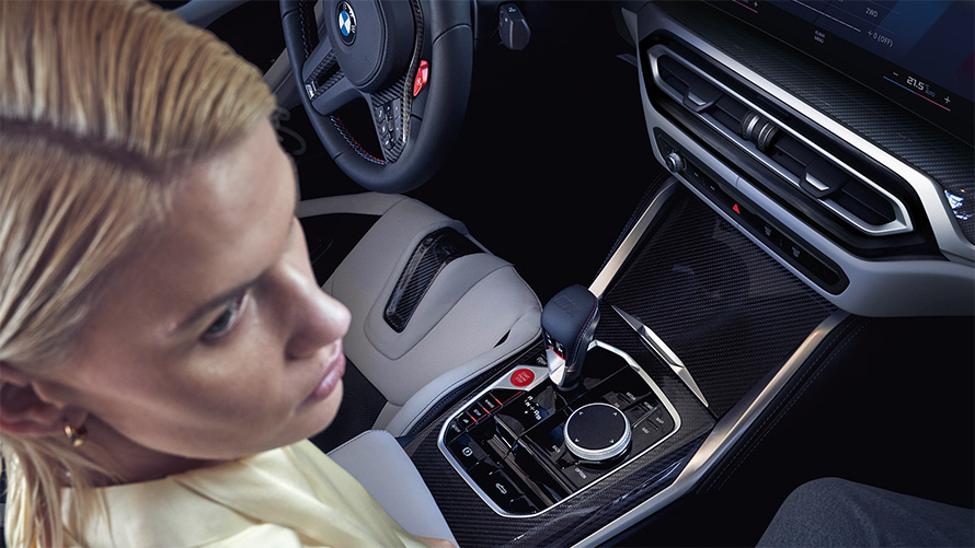 BMW M4 Cabrio Competition z M xDrive G83 2021 wnętrze konsola środkowa BMW M4 Cabrio Competition z M xDrive G83 2021 konsola środkowa i kobieta na fotelu pasażera