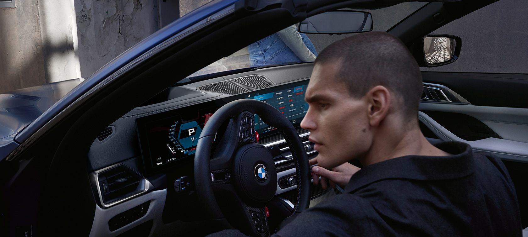 BMW M4 Cabrio Competition z M xDrive G83 2021 kokpit BMW M4 Cabrio Competition z M xDrive G83 2021 BMW Individual mroźny niebieski Portimao metalizowany przy otwartych drzwiach z mężczyzną
