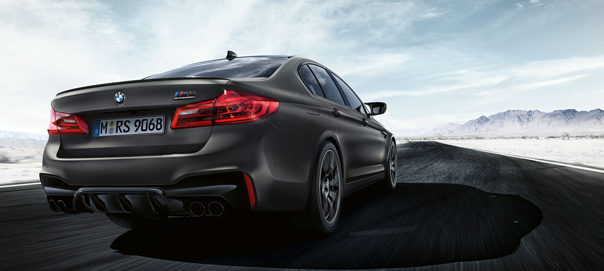 Końcówki rur wydechowych. BMW M5 edycja 35 Years, tylny półprofil podczas jazdy.