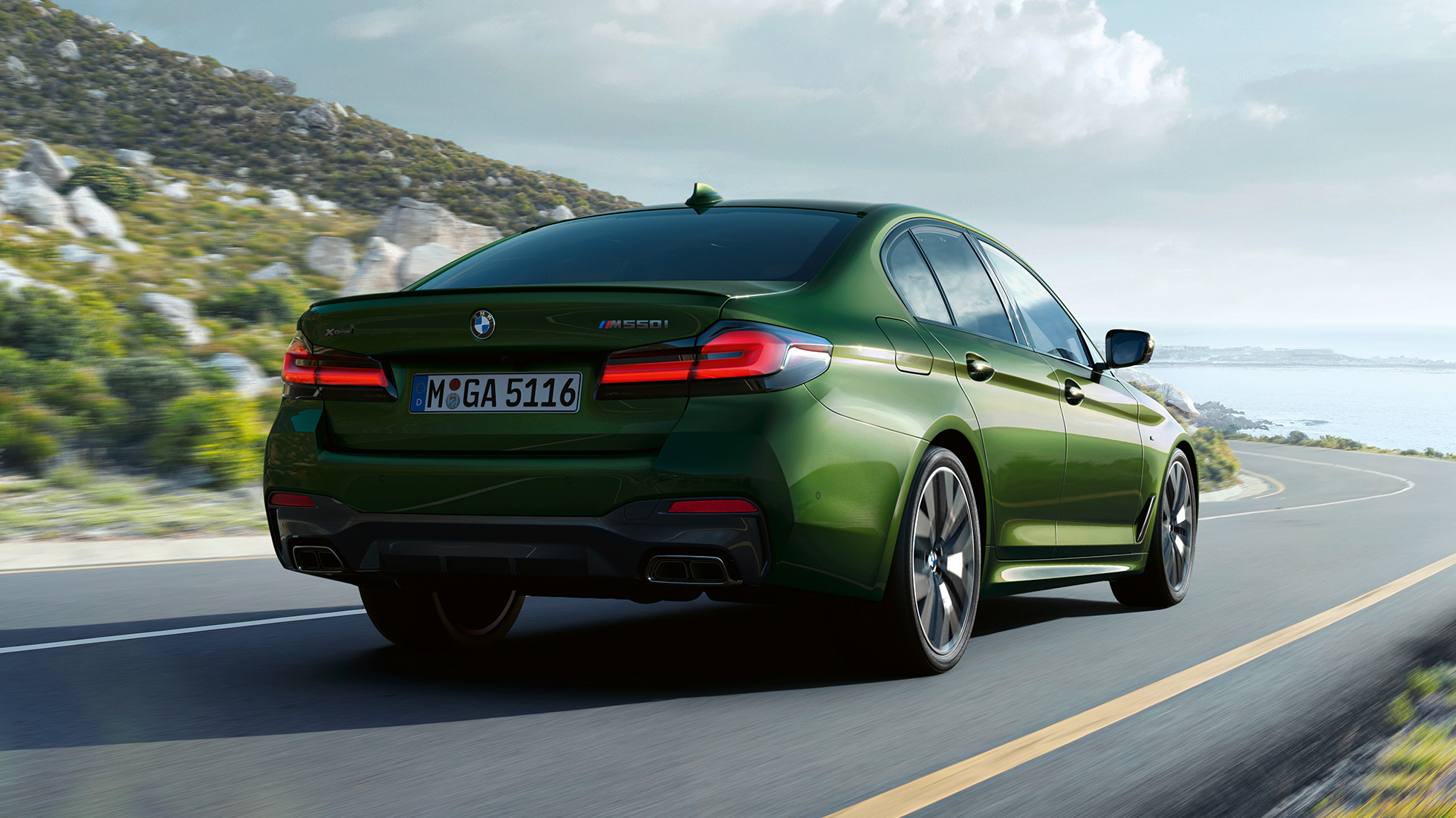 BMW M550i xDrive Limuzyna G30 LCI Facelift 2020, widok z tyłu BMW M550i xDrive Limuzyna G30 LCI Facelift 2020 BMW Individual, Verde Ermes metalizowany widok z tyłu podczas jazdy poza miastem