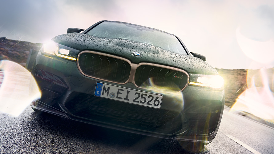 BMW M5 CS F90 2021 mroźna głęboka zieleń metalizowany, widok z przodu z włączonymi reflektorami