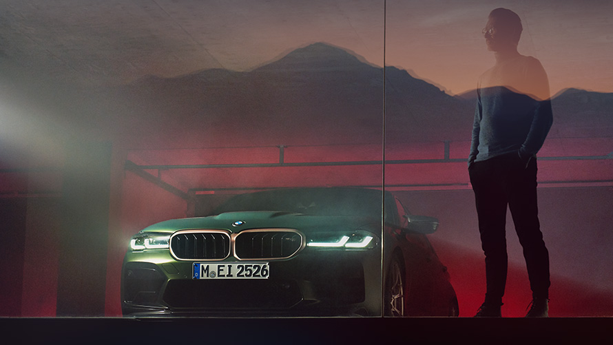 BMW M5 CS F90 2021, widok z przodu z mężczyzną BMW M5 CS F90 2021 mroźna głęboka zieleń metalizowany, widok z przodu z mężczyzną