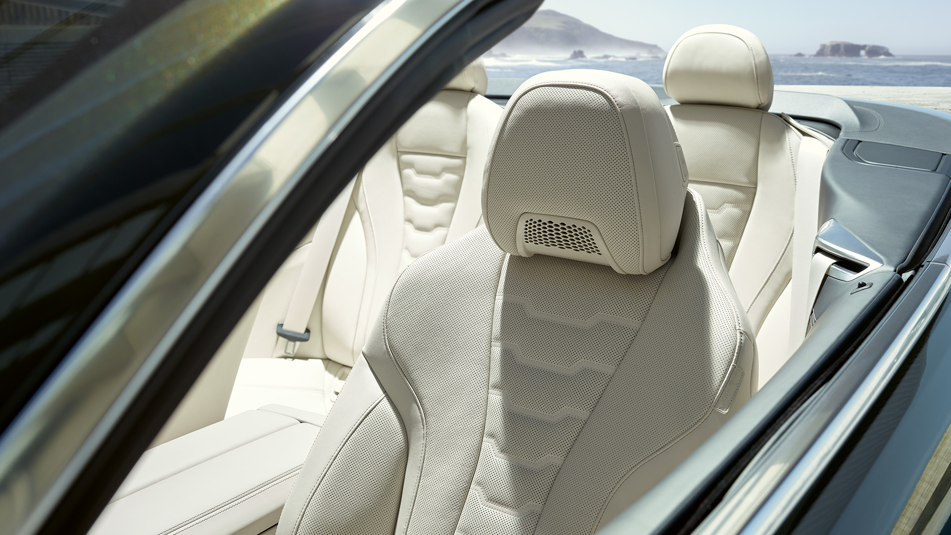 W BMW M850i xDrive Cabrio, wielofunkcyjne fotele przednie. BMW M850i xDrive Cabrio w metalizowanym kolorze szarego drawitu z otwartym dachem, wnętrze z fotelami wielofunkcyjnymi obitymi tapicerką BMW Individual ze skóry Merino w kolorze kości słoniowej.