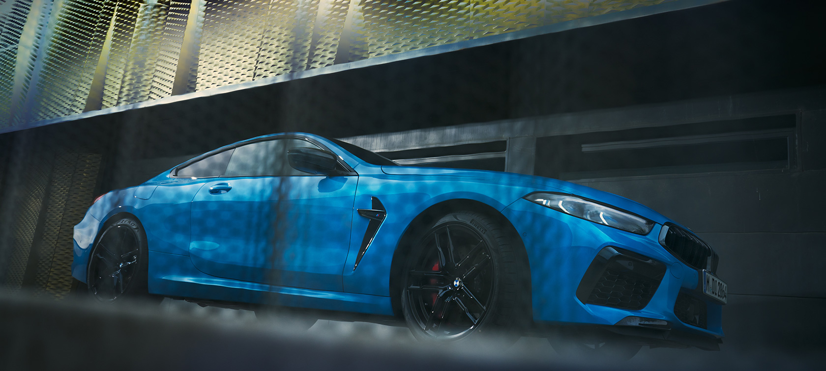 BMW M8 M Competition Coupé F92 LCI modernizacja 2022 widok z boku podczas postoju ujęcie z dołu BMW M8 Competition Coupé F92 LCI modernizacja 2022 niebieski Daytona Beach BMW Individual niemetalizowany widok z boku podczas postoju na tle budynku ujęcie z dołu