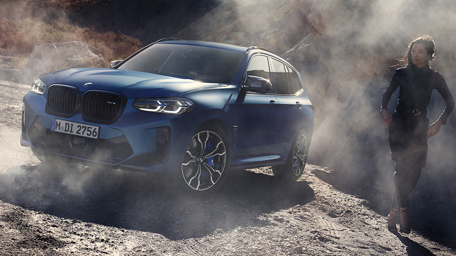 BMW X3 M Competition F97 LCI 2021 przedni półprofil podczas postoju w kamienistym terenie BMW X3 M Competition F97 LCI modernizacja 2021 mroźny niebieski Marina Bay metalizowany przedni półprofil podczas postoju w kamienistym terenie z modelką