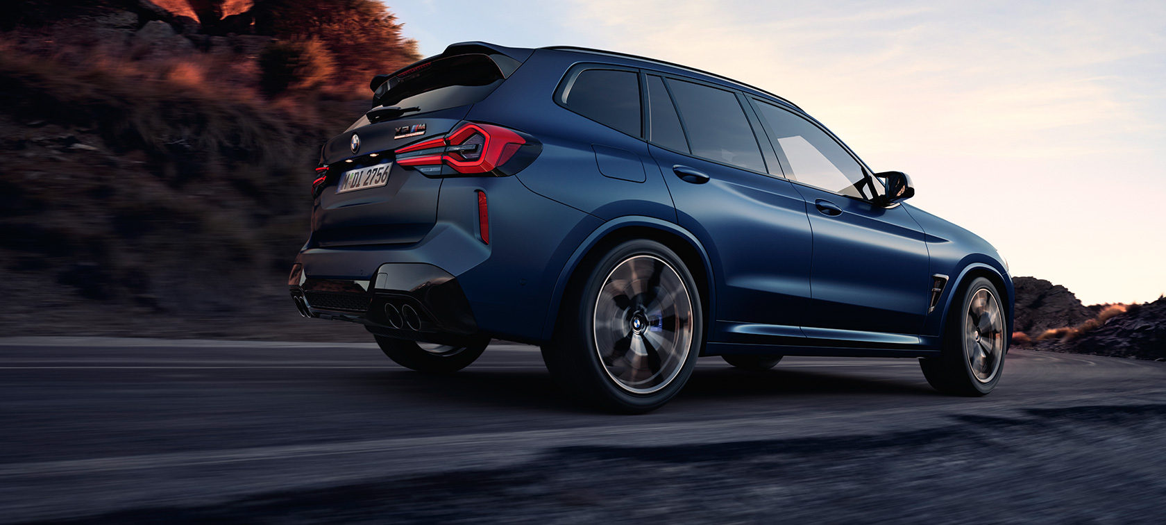 BMW X3 M Competition F97 LCI 2021 tylny półprofil widok z dołu BMW X3 M Competition F97 LCI modernizacja 2021 mroźny niebieski Marina Bay metalizowany podczas jazdy tylny półprofil widok z dołu