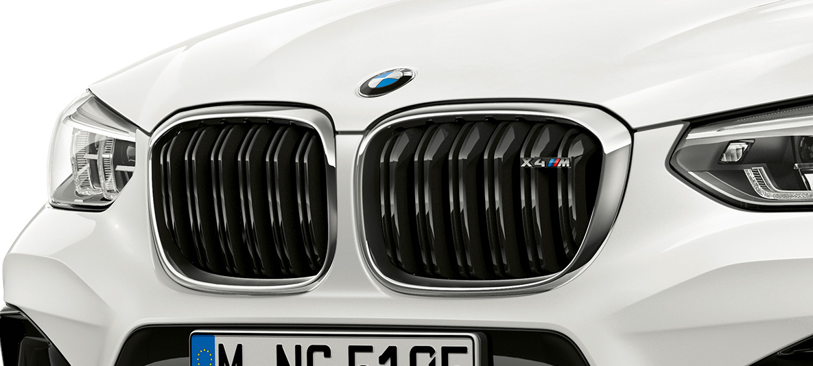 BMW X4 M, atrapa chłodnicy M. BMW X4 M, biel alpejska, wygląd zewnętrzny, przód, atrapa chłodnicy M z chromowanymi elementami i oznaczeniem modelu.