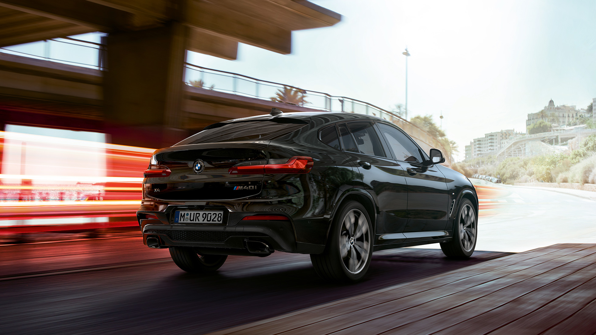 BMW X4 M40i, przedni półprofil. BMW X4 M40i, szafirowoczarny metalizowany, podczas jazdy, wygląd zewnętrzny, przedni półprofil z pasami świetlnymi.