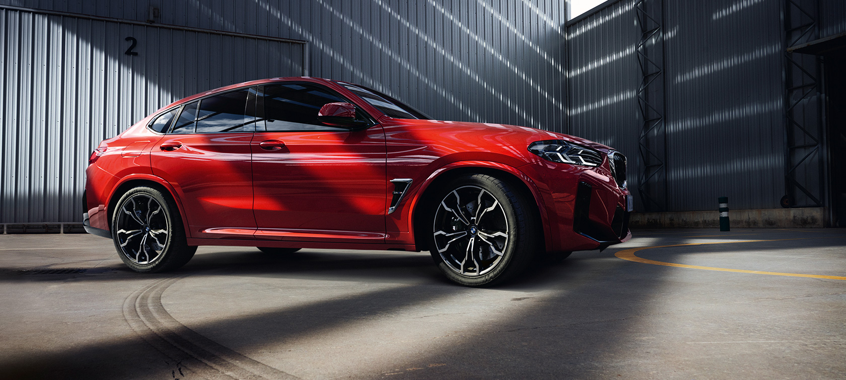 Przedni półprofil BMW X4 M F98 LCI modernizacja 2021 BMW X4 M F98 LCI modernizacja 2021 czerwień Toronto metalizowany przedni półprofil w hali fabrycznej