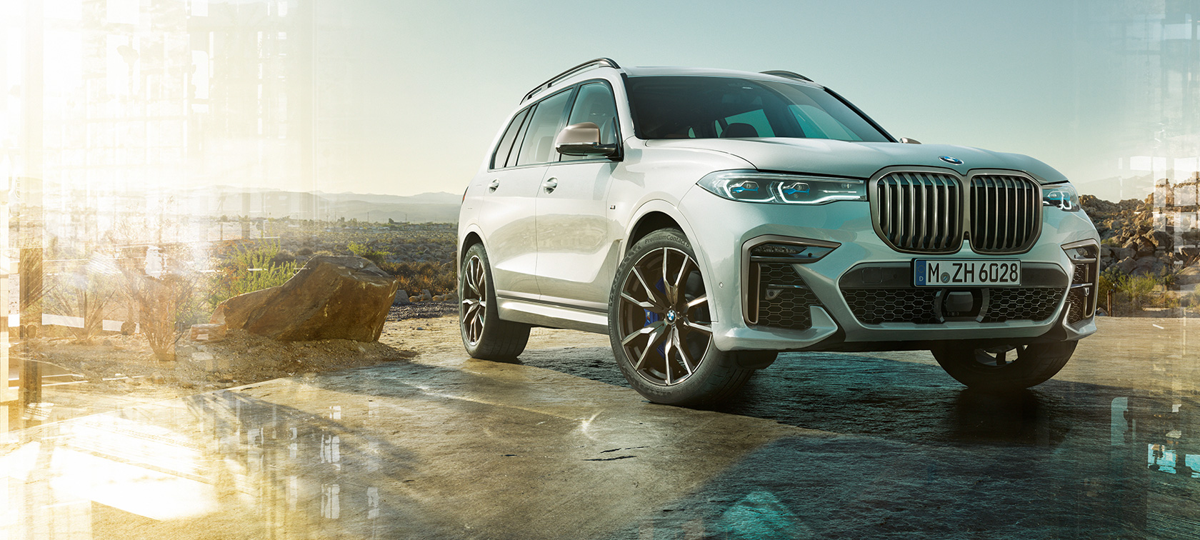 BMW X7 M , przedni lewy półprofil BMW X7 M w kolorze bieli mineralnej, G07, podczas postoju, przedni lewy półprofil