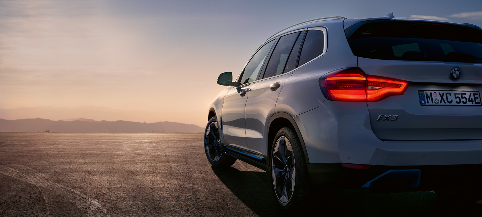 BMW iX3 G08 podczas postoju na ulicy BMW iX3 G08 2020, biel mineralna, metalizowany, tylny półprofil podczas postoju na ulicy